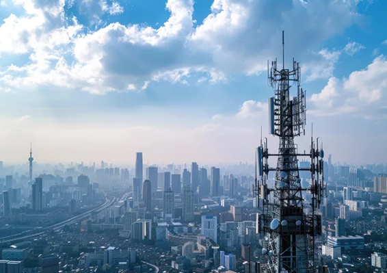 Communication tower with multiple antennas above city skyline